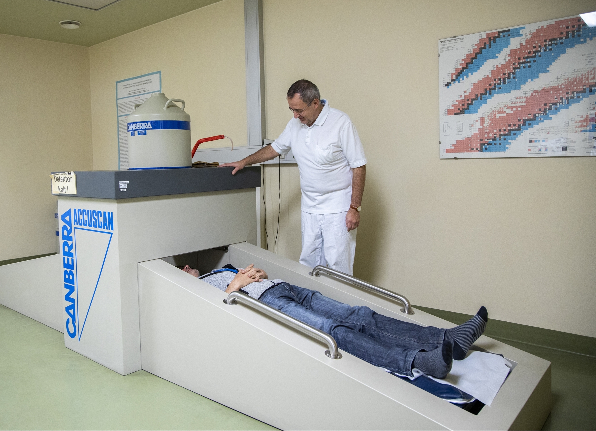 Arzt untersucht liegenden Patient in der Ambulanz für nukelarmedizinischer Diagnostik