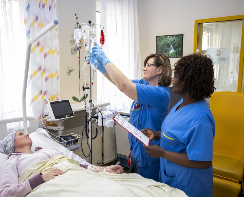 Pflegerinnen kontrollieren Infusionen einer Patientin