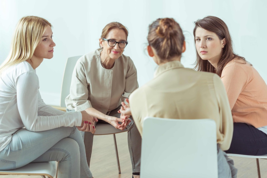 Gruppe von 4 Frauen sitzen im Sesselkreis und unterhalten sich